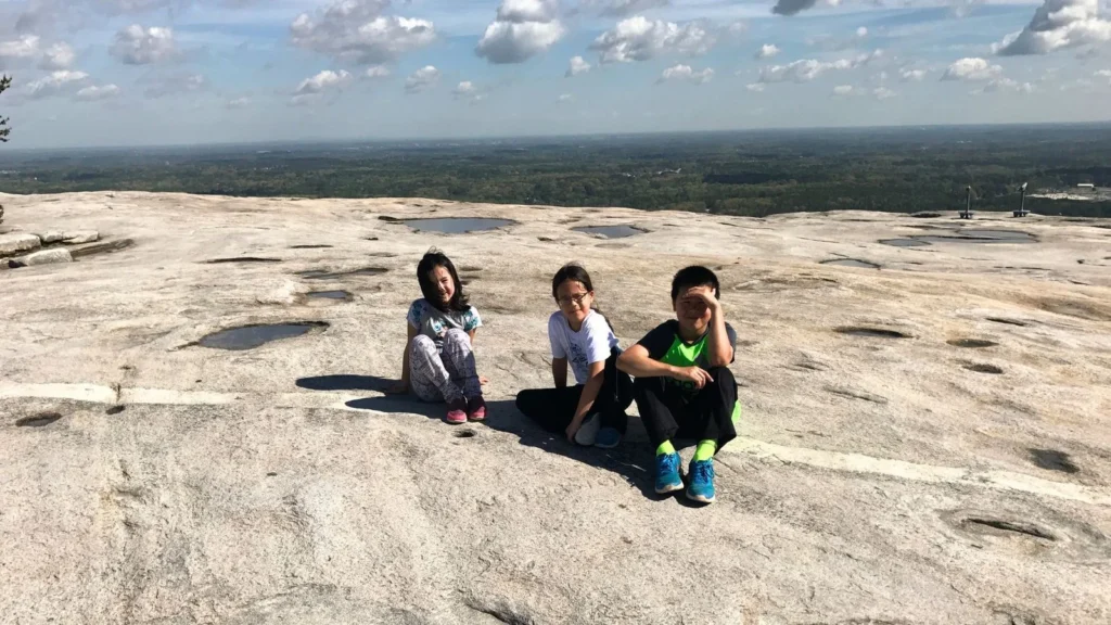 A picture of three children on top of stone mountain during a family camping trip.